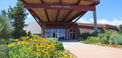 Front of the Waymire Dome with sunflowers by the sidewalk